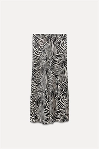 Detail shot of midi skirt featuring a black and white zebra pattern and silky texture