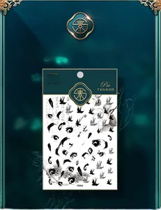 Macro shot of KX062 nail stickers featuring black ink calligraphy and swallow patterns