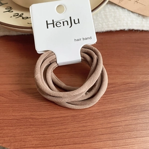 Detail of high-elasticity earth-tone hair ties set on white cardboard display
