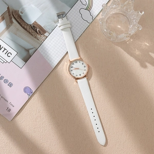 Detail of rose gold ladies' watch with white leather strap and Arabic numerals