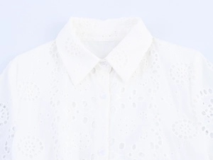 Close-up of lapel collar and hollow embroidery detail on white button-down shirt dress