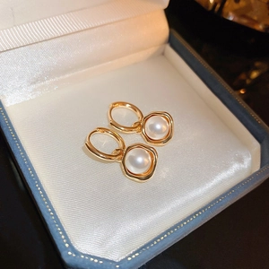 Gros plan de boucles d'oreilles vintage en or avec perle blanche dans un écrin