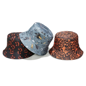 Detailed flat lay of three Halloween bucket hats featuring pumpkin, bat and ghost patterns