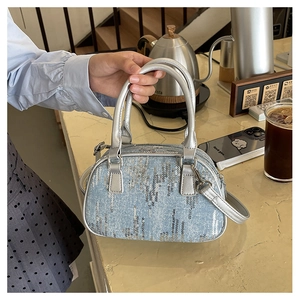 Detail of light blue denim handbag with silver sequins and metallic leather strap