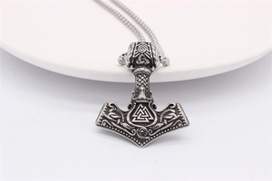 Macro detail of Nordic Viking Thor's Hammer pendant with intricate Valknut engraving