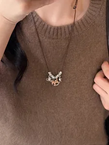 Détail du collier cheval en bois avec étoiles sur corde brune sur un pull en maille