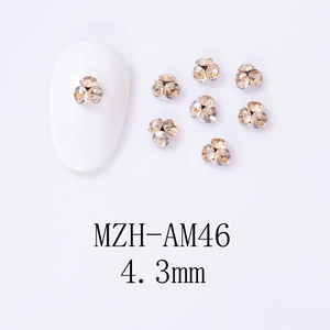 Macro detail of 4.3mm champagne gold rhinestone flower charms for nail art design