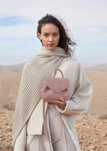 Pink premium leather handbag with handle and strap shown against a desert backdrop
