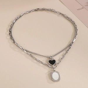 Double-layered silver necklace featuring a black heart and white rectangular pendants