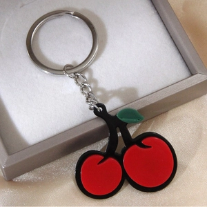 Portachiavi a ciliegia chic con foglie verdi e anello d'argento in una scatola regalo