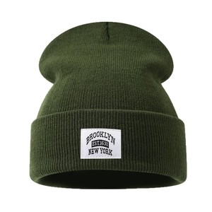Dark green Brooklyn knitted beanie hat with vintage patch on a clean white background