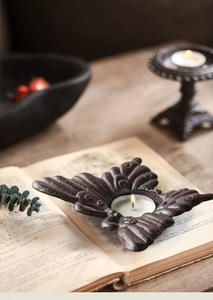 Detailopname van vintage gietijzeren vlinder kaarsenhouder met rustieke textuur op hout