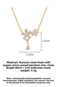 Detailed view of titanium steel gold necklace with double zircon flowers and drop pendant