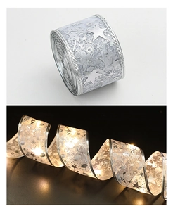Detail of silver double-layered LED ribbon with warm star and music note light patterns