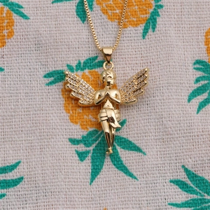 Detail of gold angel pendant with white micro-zirconia wings on a fine box chain