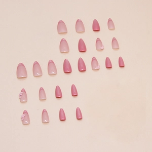 Pink French almond press-on nails with 3D floral accents and glossy cat-eye finish