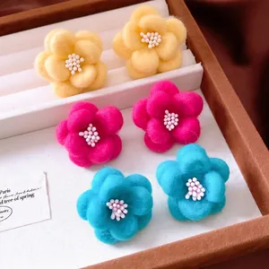 Three pairs of colorful wool flower stud earrings in yellow, pink and blue for autumn