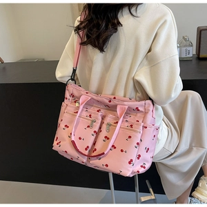 Pink tote bag with cherry print showing side zipper pockets and large storage space