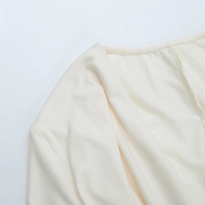 Gros plan du décolleté dos nu en tricot beige montrant la texture et les coutures nettes