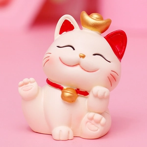Close-up of cute white lucky cat figurine with gold ingot and red collar detail