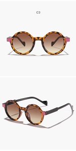 Detail view of round tortoiseshell sunglasses with pink wing accents and tea gradient lenses