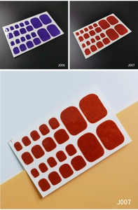 Detailed view of glittering purple and orange adhesive toe nail stickers with glossy texture