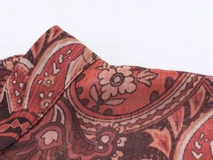 Detailed close-up of a bohemian paisley print collar on a red chiffon blouse