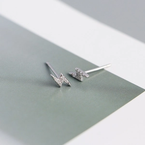 Macro shot of silver lightning bolt stud earrings featuring sparkling inset crystals
