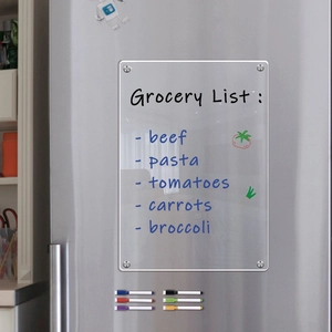 Macro view of magnetic acrylic dry erase board with grocery list on stainless steel fridge