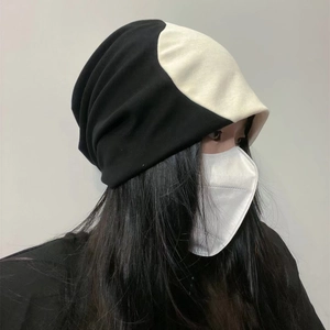 Vue détaillée d'un bonnet en tricot bicolore noir et blanc avec texture souple et plissée