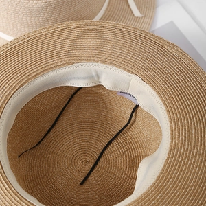 Detail of hand-woven raffia sun hat showing inner sweatband and elastic chin strap