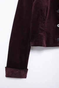 Détail du poignet d'une veste en velours bordeaux avec revers et boutonnière