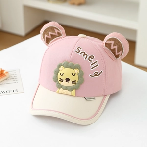 Détail d'une casquette enfant rose et beige avec écusson lion 3D et oreilles