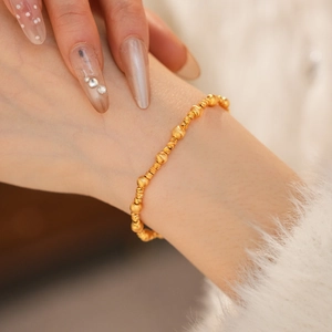 Detailed view of 24k gold-plated beaded bracelet with matte and spiral texture beads