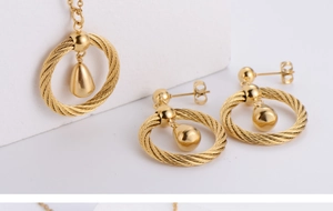Detail of gold-plated titanium steel jewelry set with twisted rope texture and water drop charms