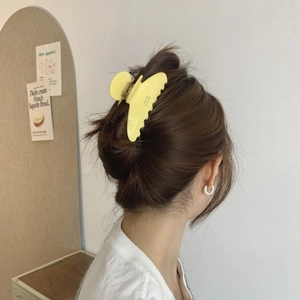 Chic yellow acetate hair claw clip with wavy edges for elegant French style updos
