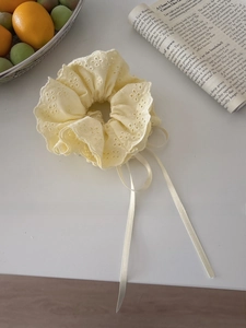 Detail of light yellow lace scrunchie with floral embroidery and long ribbon ties