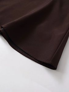 Vue détaillée de l'ourlet de robe marron foncé avec coutures et texture du tissu