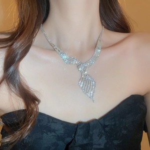 Detailed view of silver leaf tassel necklace with sparkling rhinestones on model