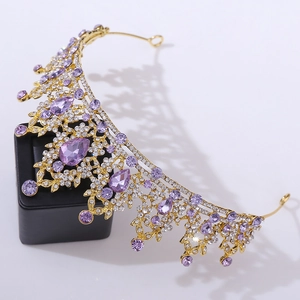 Luxurious gold bridal crown with purple crystals and rhinestones on a black base