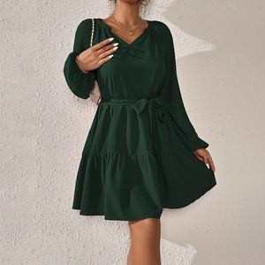 Elegante abito verde scuro a maniche lunghe con scollo a V, cintura e gonna a balze