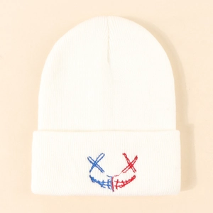 Bonnet en tricot blanc avec broderie visage souriant rouge et bleu et bord à revers