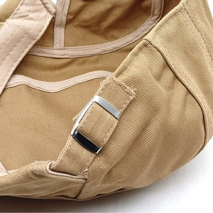 Detail of khaki cotton newsboy cap featuring an adjustable silver metal slider buckle