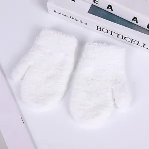 Close-up of soft white coral fleece mittens for kids with fluffy plush texture