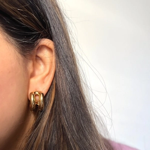 Double-line C-shaped 18K gold stainless steel earrings on model with neutral background