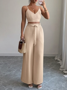 Dettaglio del completo beige due pezzi con top con scollo a V e pantaloni a gamba larga