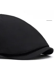 Detail view of the wide curved brim and reinforced stitching on the black flat cap