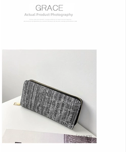 Detail shot of long woven wallet with black and grey tweed texture and gold zipper