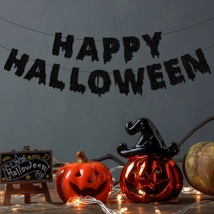 Glittering black Happy Halloween banner with orange pumpkin lantern for festive home decor