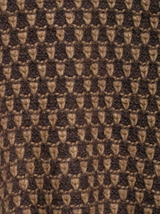 Macro shot of vintage brown geometric knit fabric with detailed textured jacquard pattern